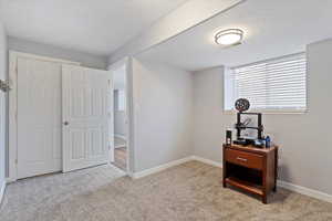 Bedroom with light carpet, baseboards, visible vents, and a textured ceiling