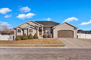 Ranch-style house with a garage, fence, concrete driveway, and stucco siding