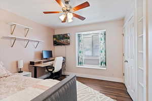 Bedroom featuring dark wood-type flooring, ceiling fan, and baseboards