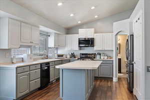 Kitchen with a center island, stainless steel appliances, light countertops, gray cabinetry, and a sink