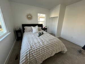 Carpeted bedroom with visible vents and baseboards