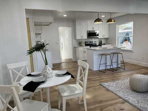 Dining space with light wood-style flooring, baseboards, and recessed lighting