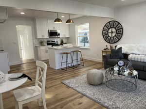 Living room featuring light wood-type flooring, baseboards, and recessed lighting