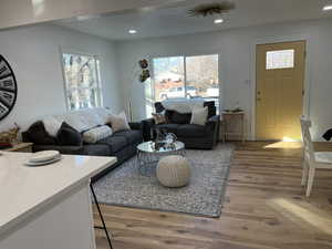 Living room featuring a healthy amount of sunlight, wood finished floors, and recessed lighting