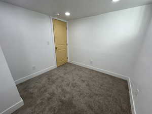 Carpeted empty room featuring recessed lighting and baseboards