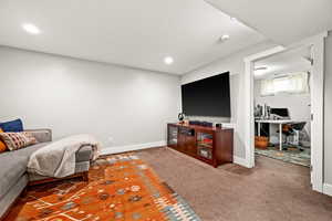 Living room featuring carpet floors, recessed lighting, a textured ceiling, and baseboards