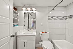 Bathroom featuring shower / bathing tub combination, vanity, and toilet