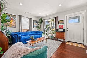 Living room with recessed lighting, visible vents, a textured ceiling, and wood finished floors