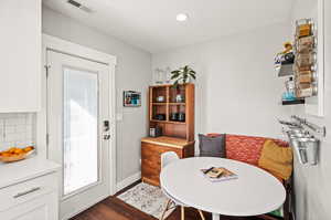 Dining space featuring dark wood-style flooring, recessed lighting, visible vents, and baseboards