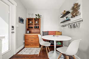 Dining area with baseboards, breakfast area, and dark wood-type flooring