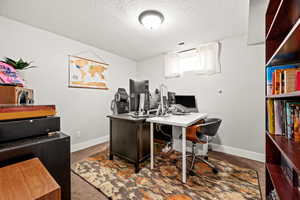 Carpeted office with a textured ceiling, visible vents, and baseboards