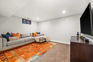 Living room with baseboards, visible vents, carpet flooring, and recessed lighting