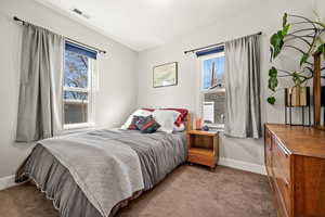 Bedroom with carpet, visible vents, and baseboards