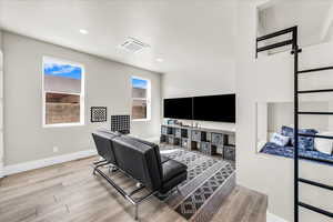 Living area with a wealth of natural light, baseboards, visible vents, and wood finished floors