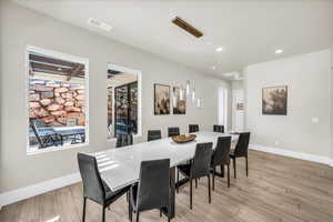 Dining area with light wood-type flooring, baseboards, and visible vents