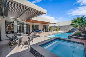 View of swimming pool with a patio, a fenced backyard, an outdoor hangout area, an in ground hot tub, and a fenced in pool