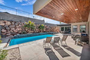 View of pool with a fenced in pool, a fenced backyard, an outdoor hangout area, an in ground hot tub, and a patio area