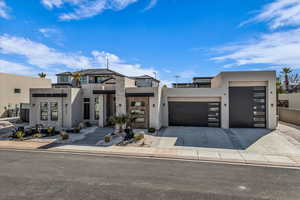 Contemporary house featuring driveway, an attached garage, and stucco siding