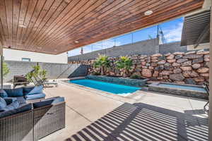 View of pool with an outdoor living space, a patio area, a fenced backyard, and a fenced in pool