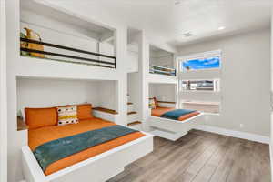 Bedroom featuring recessed lighting, visible vents, baseboards, and wood finished floors