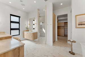 Bathroom with a marble finish shower, visible vents, a sink, marble finish floor, and two vanities