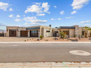 View of front of home featuring stucco siding, concrete driveway, an attached garage, fence, and stone siding