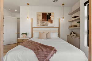 Bedroom with light wood finished floors, visible vents, and recessed lighting