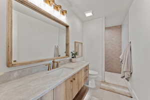 Bathroom with tile patterned flooring, vanity, toilet, and walk in shower