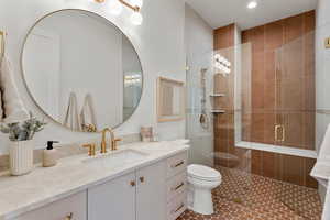 Full bathroom with a stall shower, vanity, toilet, and tile patterned floors