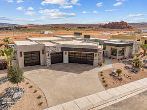 View of front of house with a garage, a mountain view, driveway, and stucco siding