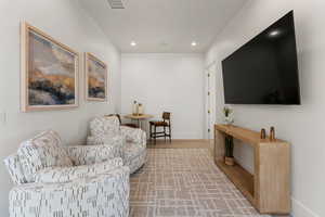 Living area featuring baseboards, wood finished floors, visible vents, and recessed lighting