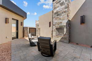 View of patio featuring an outdoor stone fireplace