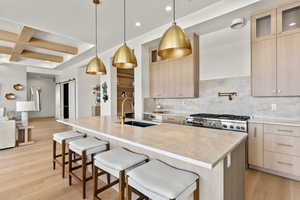 Kitchen with a barn door, a sink, and light brown cabinetry