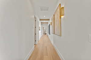 Hallway featuring recessed lighting, light wood-type flooring, visible vents, and baseboards