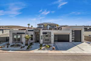 Contemporary house with driveway, stone siding, an attached garage, and stucco siding