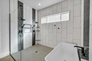 Full bath with recessed lighting, a freestanding tub, and a tile shower