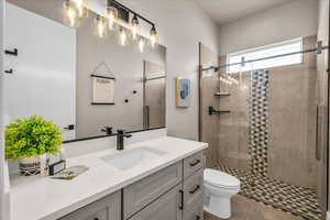 Bathroom featuring vanity, a shower stall, toilet, and tile patterned floors