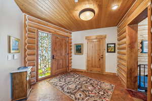 Entryway featuring wooden ceiling and baseboards