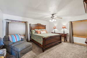 Bedroom featuring carpet floors, ceiling fan, baseboards, and a textured ceiling