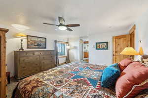 Carpeted bedroom featuring a textured ceiling, a ceiling fan, and baseboards