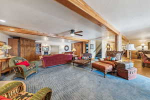 Carpeted living room with a textured ceiling, recessed lighting, a ceiling fan, stairs, and beam ceiling