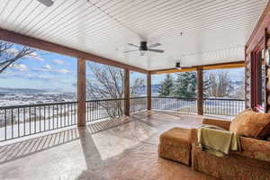 Sunroom with a mountain view and a ceiling fan