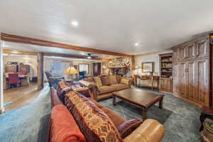 Living room with recessed lighting, beamed ceiling, and a textured ceiling