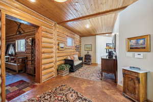 Sitting room featuring recessed lighting, wooden ceiling, and log walls