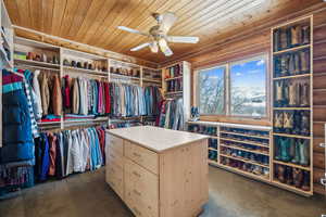 Spacious closet with dark carpet and ceiling fan