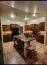 Kitchen featuring visible vents, appliances with stainless steel finishes, backsplash, a breakfast bar area, and a sink