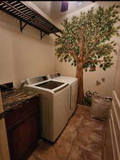 Laundry room with cabinet space, ceiling fan, light tile patterned flooring, and independent washer and dryer