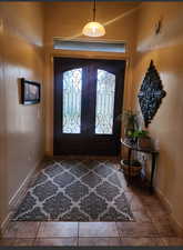 Tiled foyer entrance featuring french doors, visible vents, and baseboards