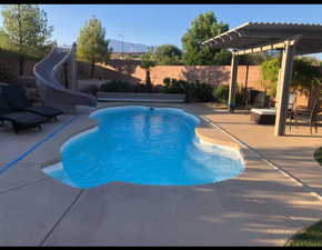 View of swimming pool with a patio, a water slide, a fenced backyard, a fenced in pool, and a pergola