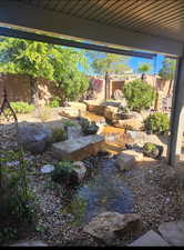 View of yard featuring a fenced backyard and a small pond